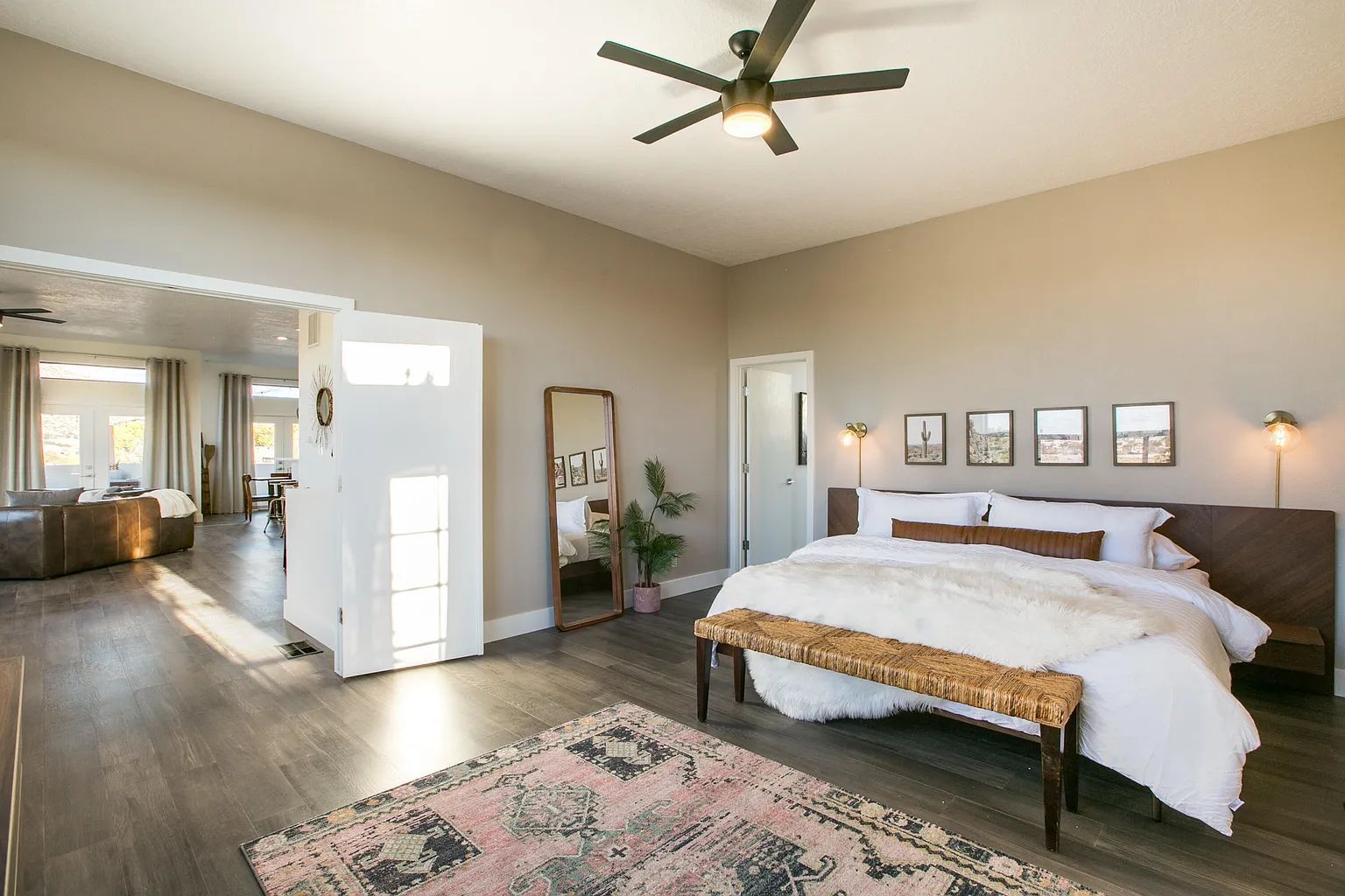 A bedroom with a large bed and a ceiling fan.