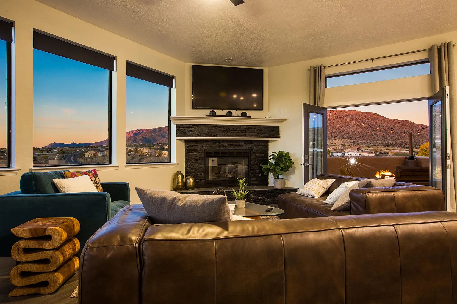 A living room with a couch , chair , fireplace and television.