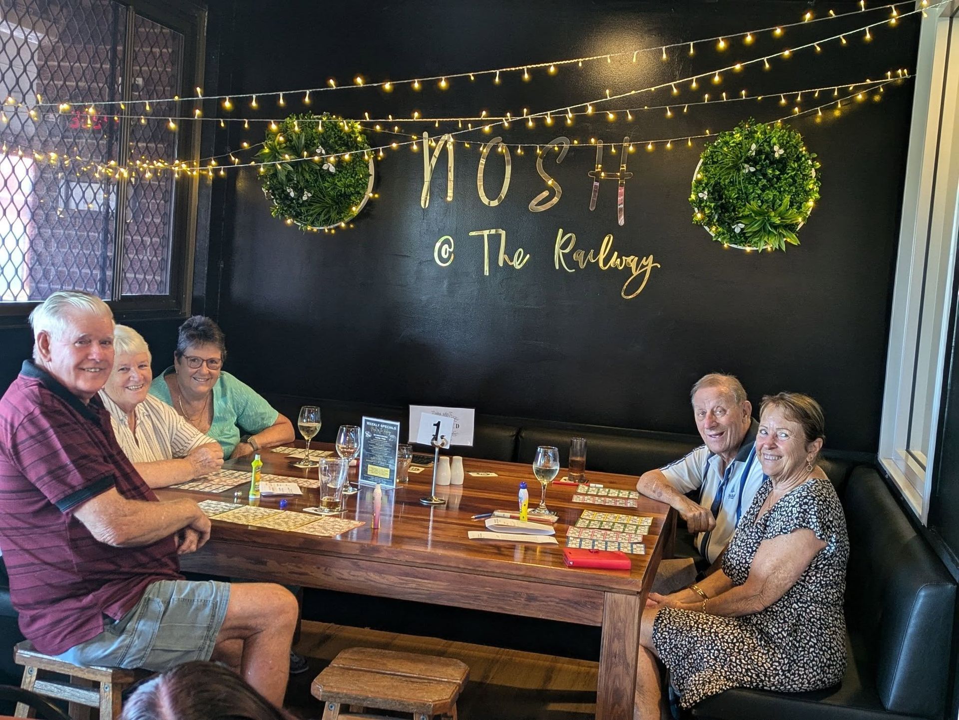 A Man Is Blowing Out Candles On A Birthday Cake At A Party — Taree Railway Bowling Club Ltd In Taree, NSW