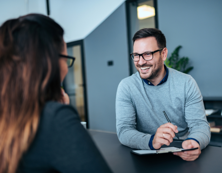 A man and a woman are sitting at a table having an interview.