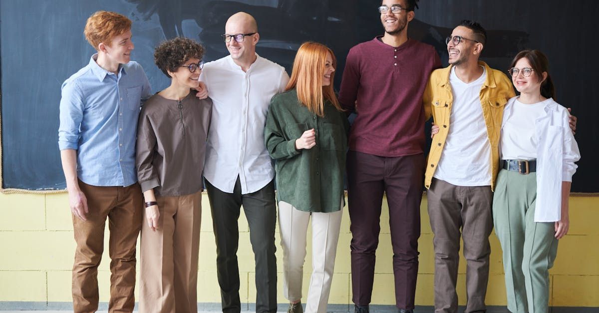 A group of people are standing next to each other in front of a blackboard.