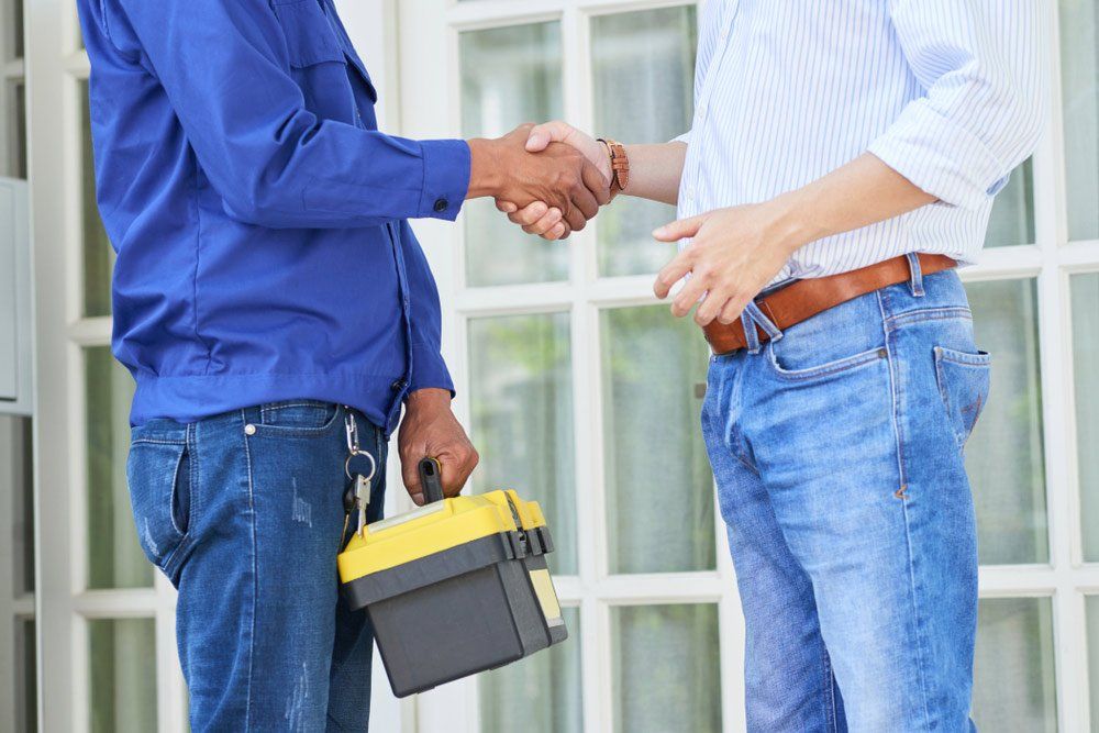 Man Thanks The Repairman For The Good Work And Shaking Hands With Client  — Emergency Electrician in Redlynch, QLD