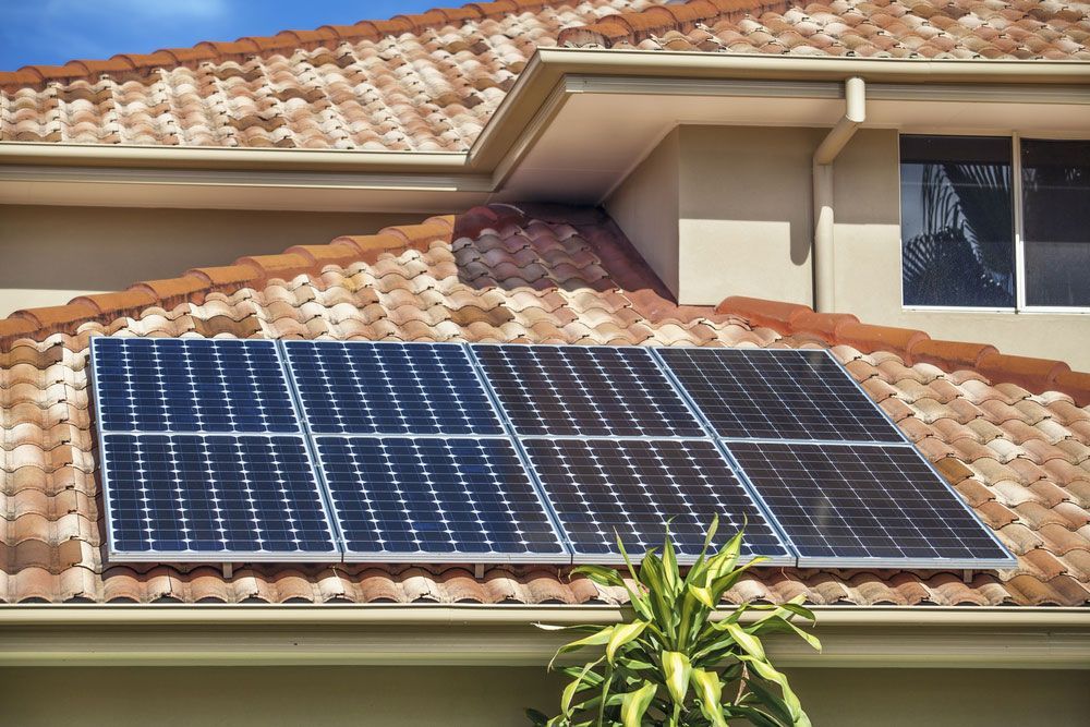 Rooftop solar panels installed on a terracotta tiled roof generating renewable energy.