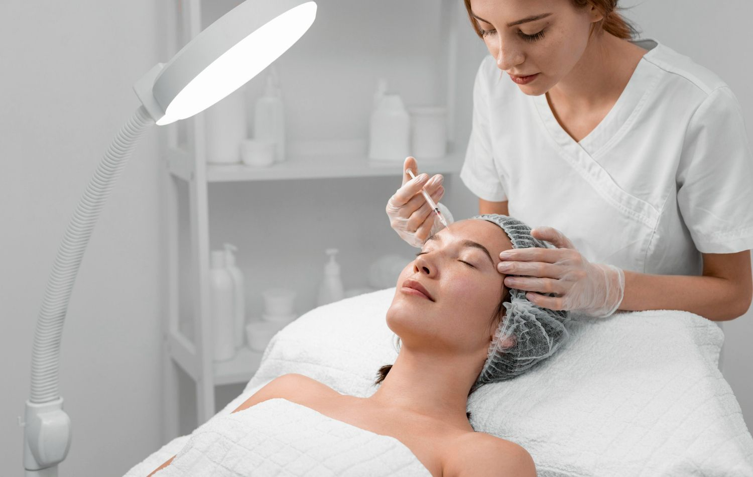 A woman is getting a facial treatment at a beauty salon.