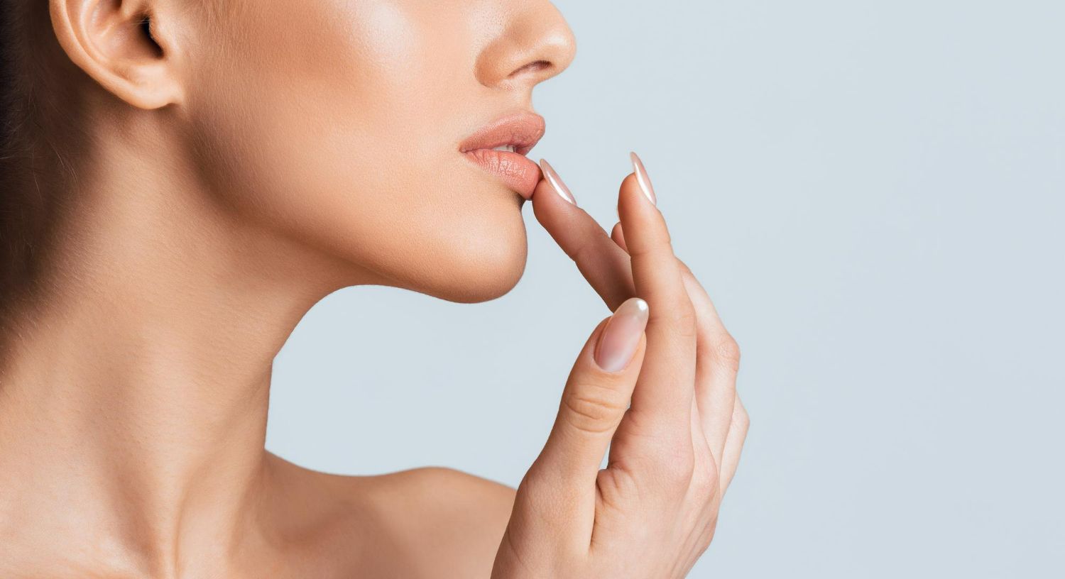 A close up of a woman 's face with her hand on her lips.
