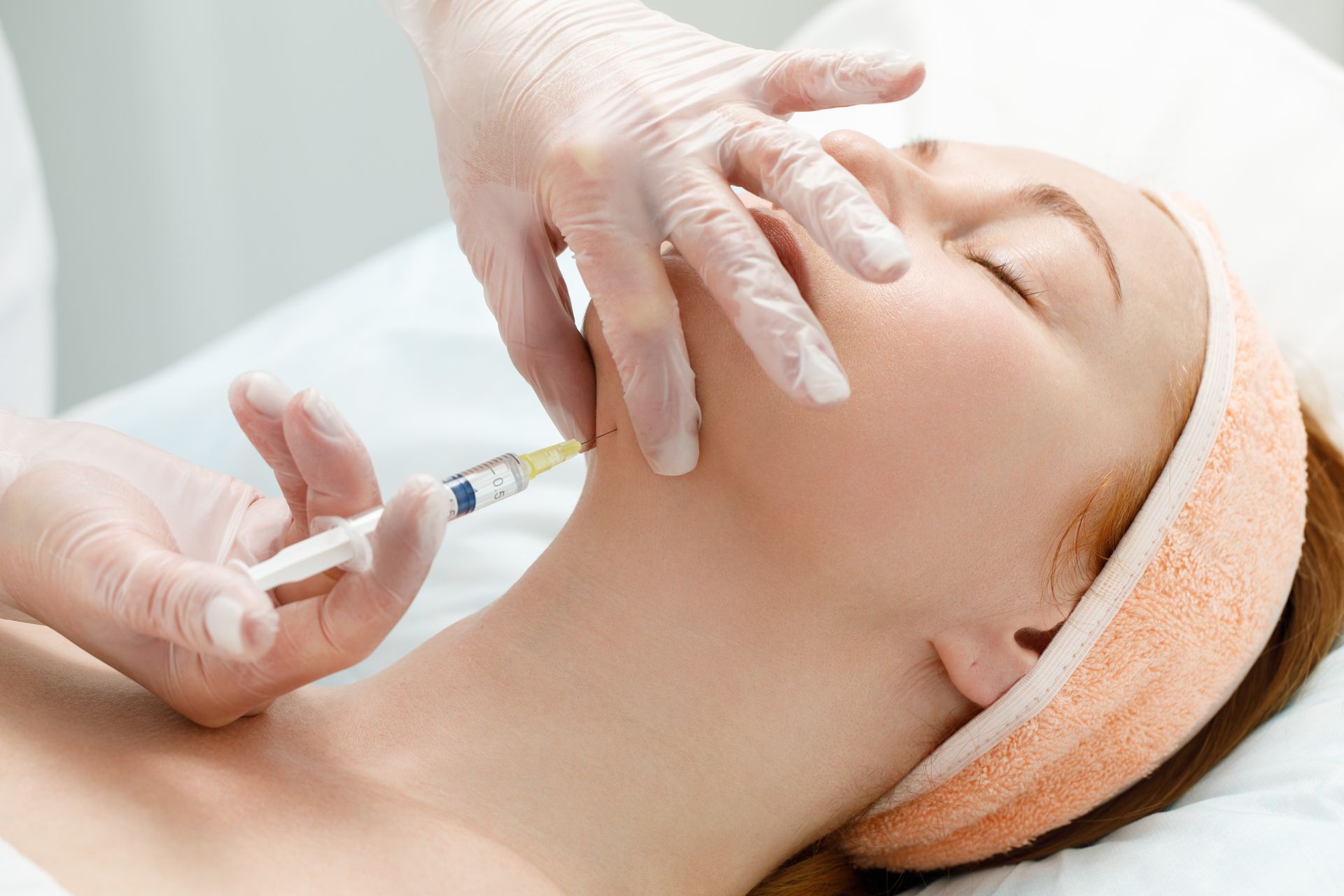 a woman is getting a botox injection in her neck .