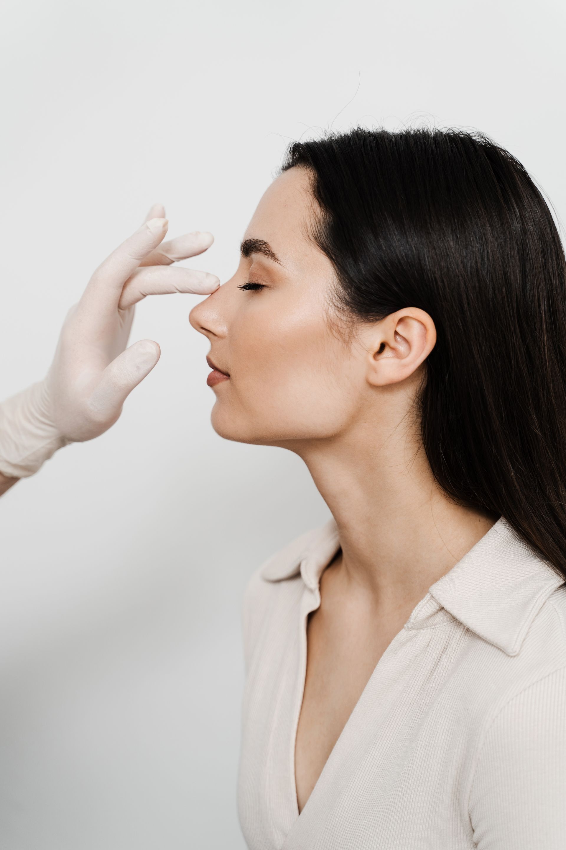 a woman is getting her nose examined by a doctor .