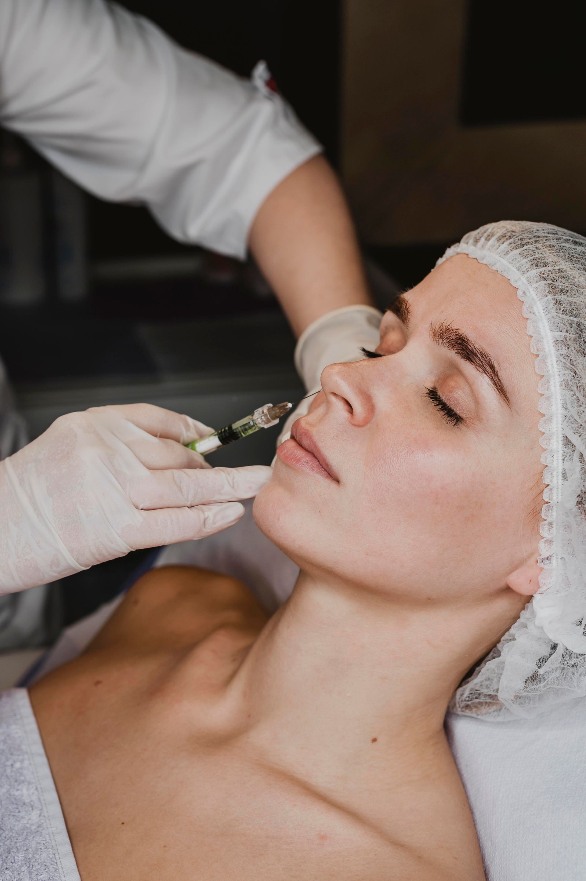 A woman is getting a botox injection in her face.