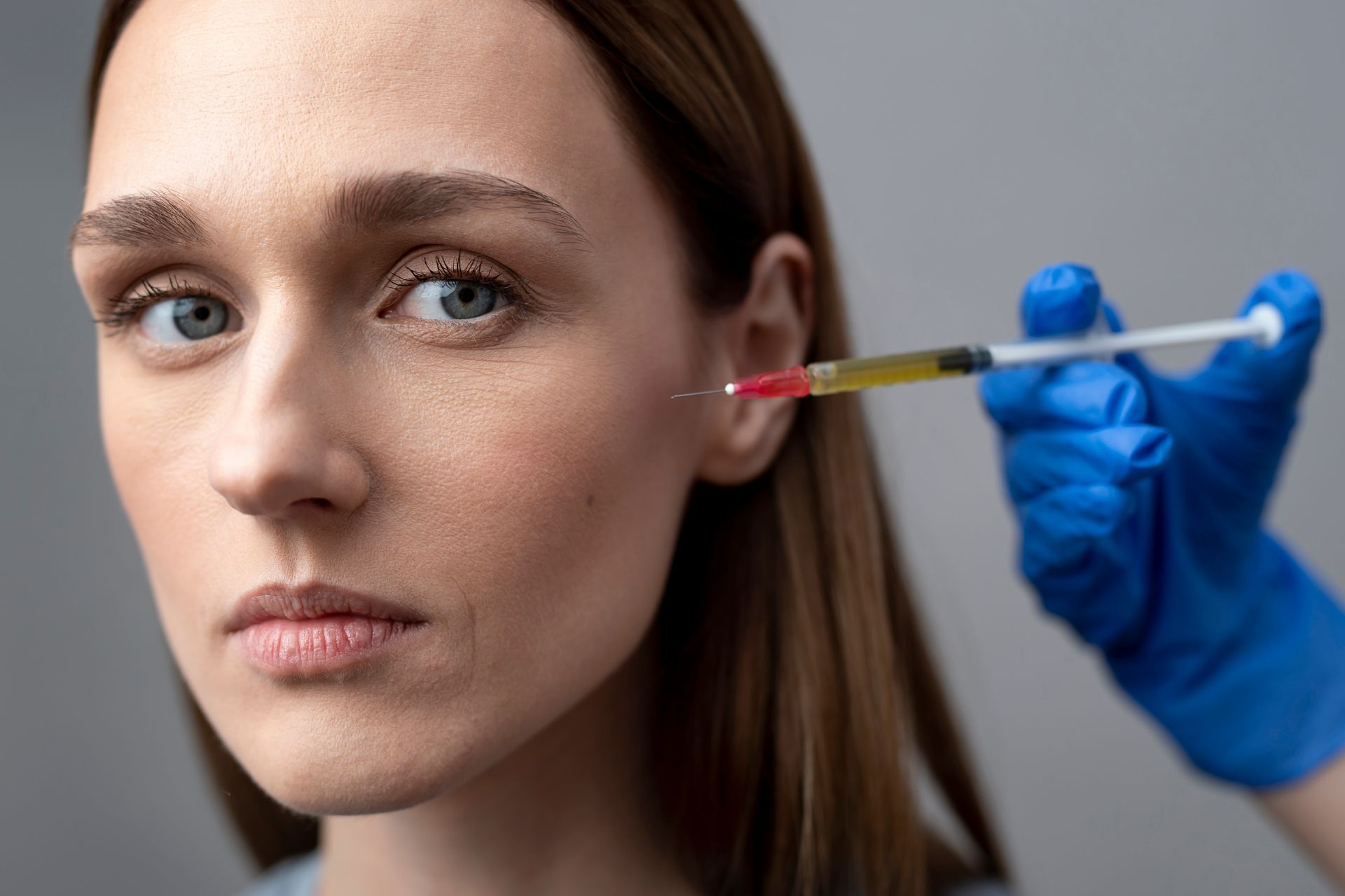 A woman is getting a botox injection in her face.