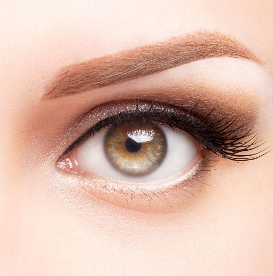 A close up of a woman 's eye with makeup and long eyelashes.