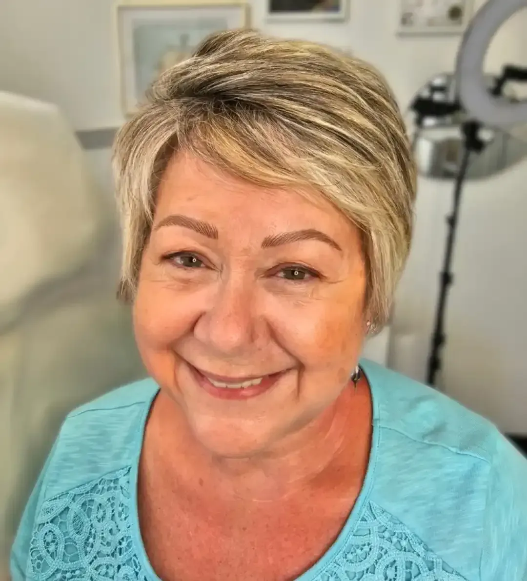 A woman in a blue shirt is smiling for the camera