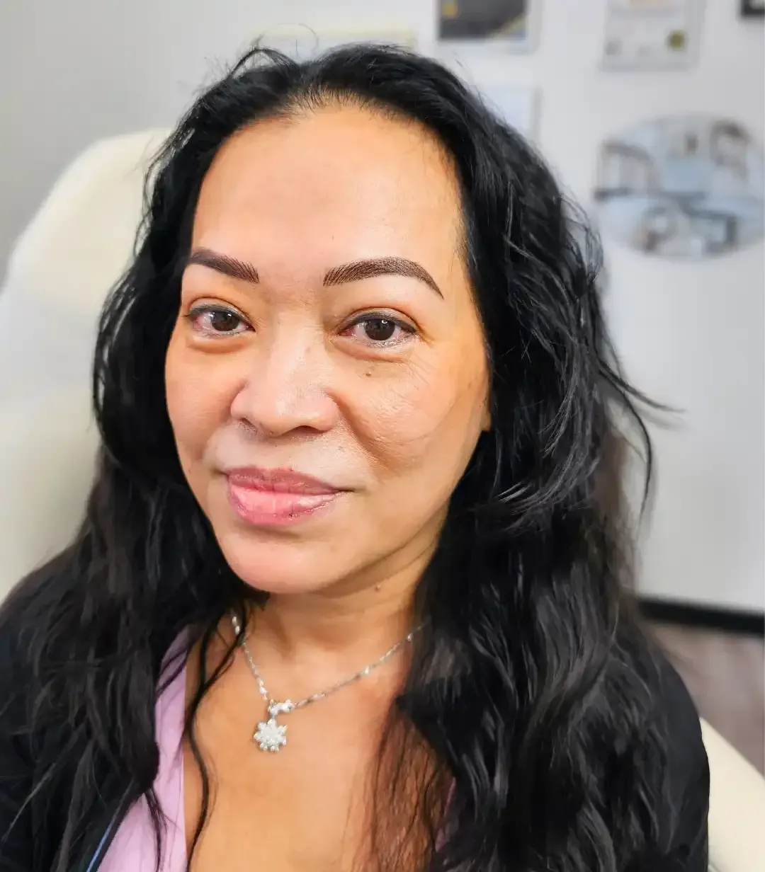 A close-up of a woman's face wearing a necklace