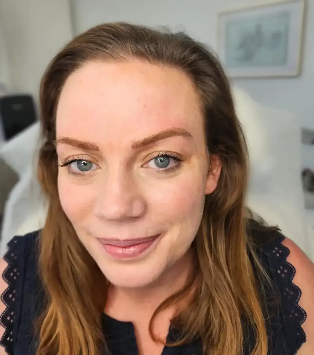 A close up of a woman 's face with a smile on her face
