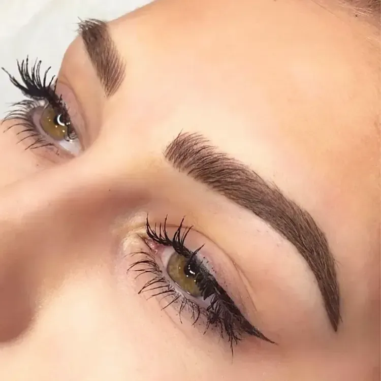 A close up of a woman 's face with long eyelashes and eyebrows.