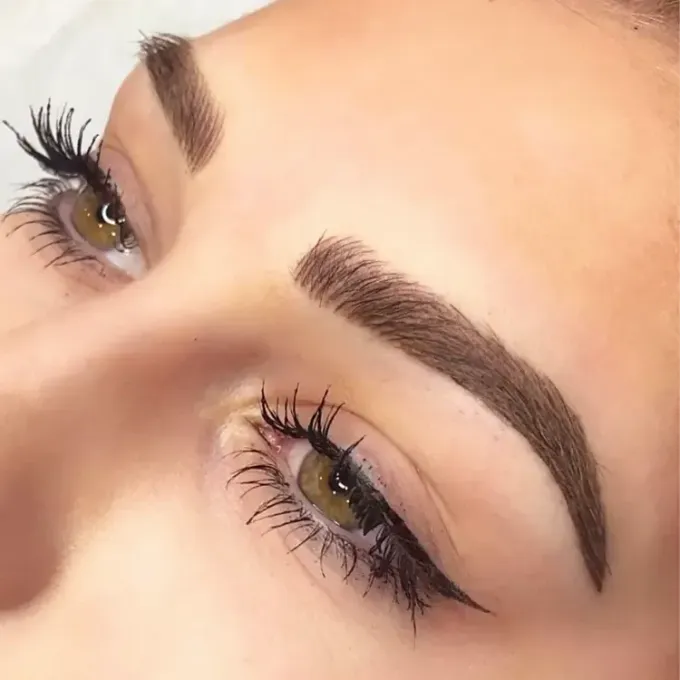 A close up of a woman 's face with long eyelashes and eyebrows.