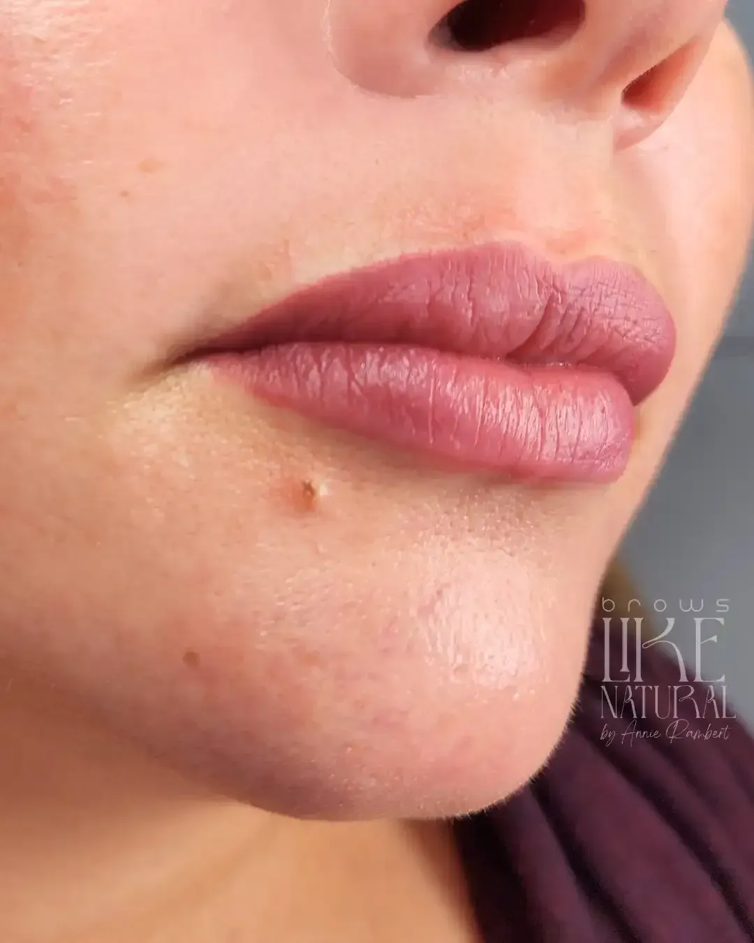 A close up of a woman 's lips with pink lipstick.