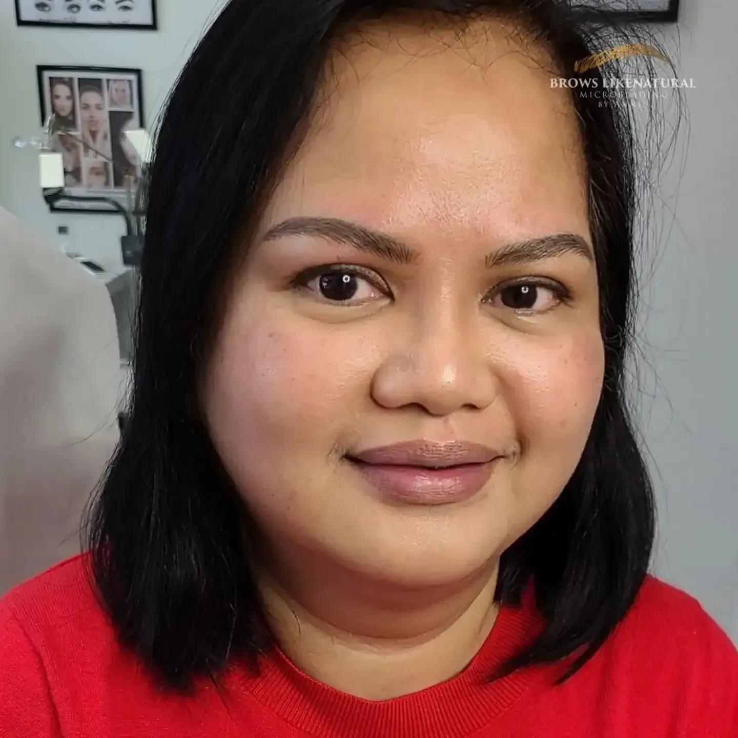 A close up of a woman 's face wearing a red shirt