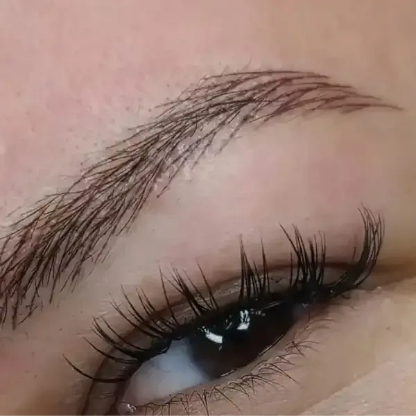 A close up of a woman 's eye with long eyelashes.