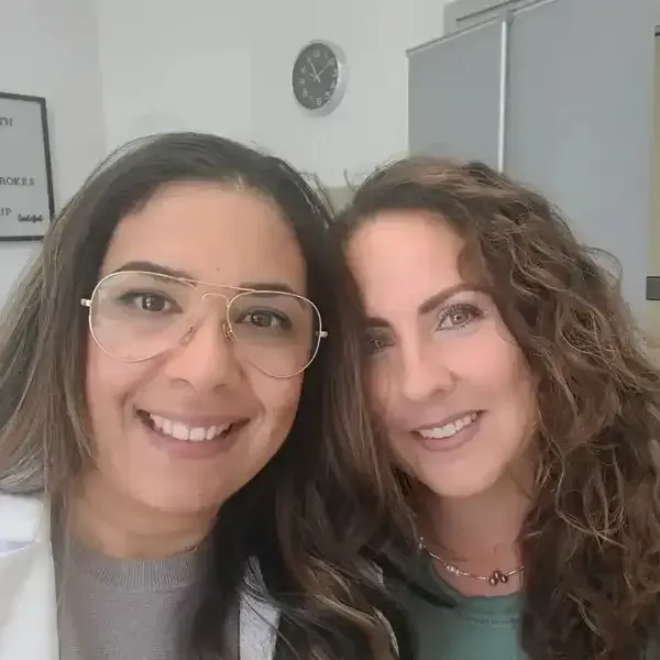 Two women wearing glasses are posing for a picture together.
