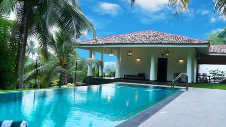 a large swimming pool with a house in the background