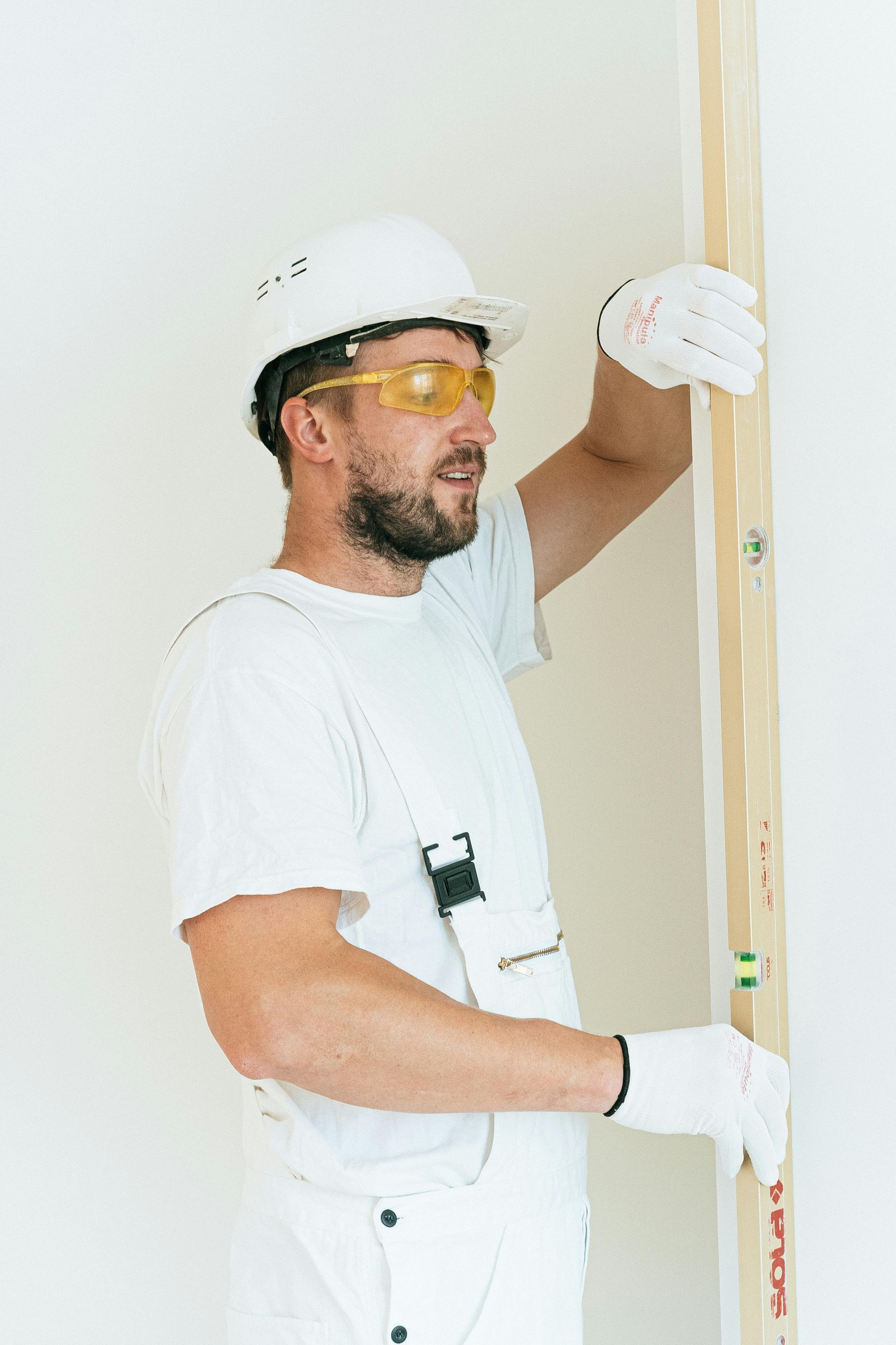 a construction worker making sure a wall is level