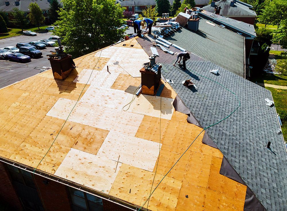 roofers working to replace an entire roof on a house