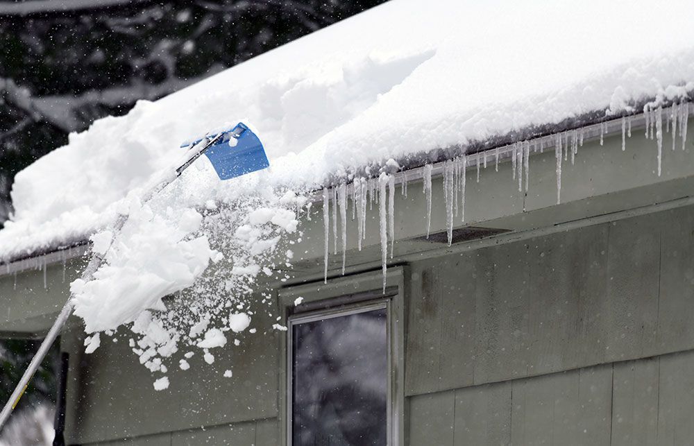 raking the snow off a roof
