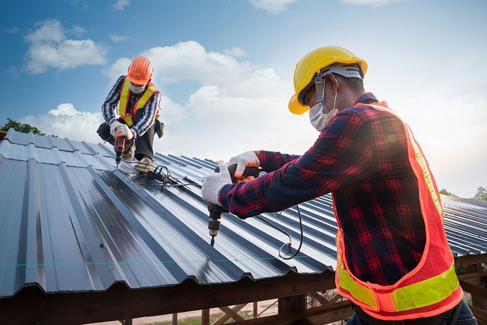 diligent roofers working hard to install a new metal roof