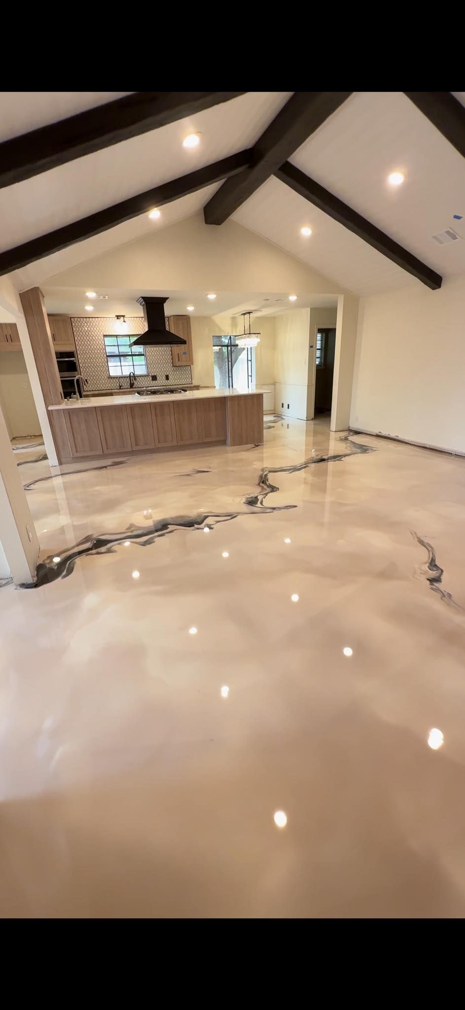 Woman in straw hat smiles, holding wine glass near a lake.