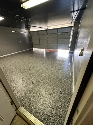 Woman in straw hat smiles, holding wine glass near a lake.