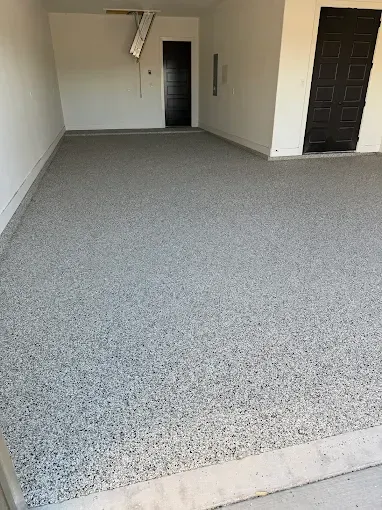 Woman in straw hat smiles, holding wine glass near a lake.