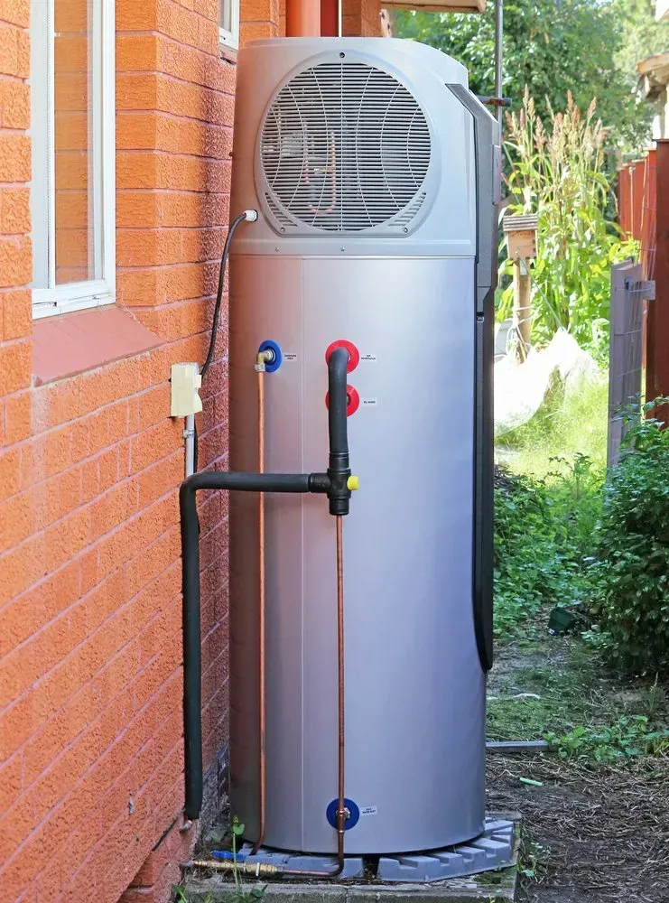 Silver Heat Pump Next to a Brick Wall — Hot Water Systems in Central Coast, NSW