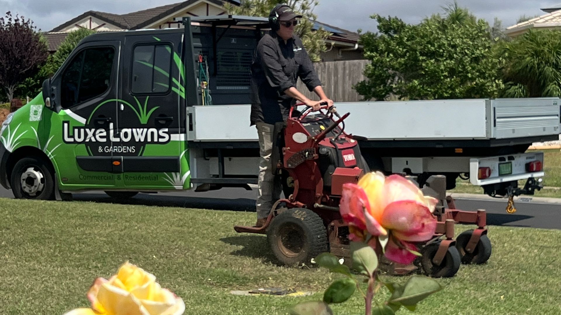 Man on turn key mower in front of a truck