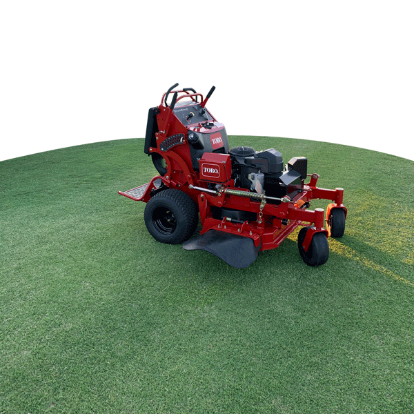A red toro lawn mower is sitting on a lush green field