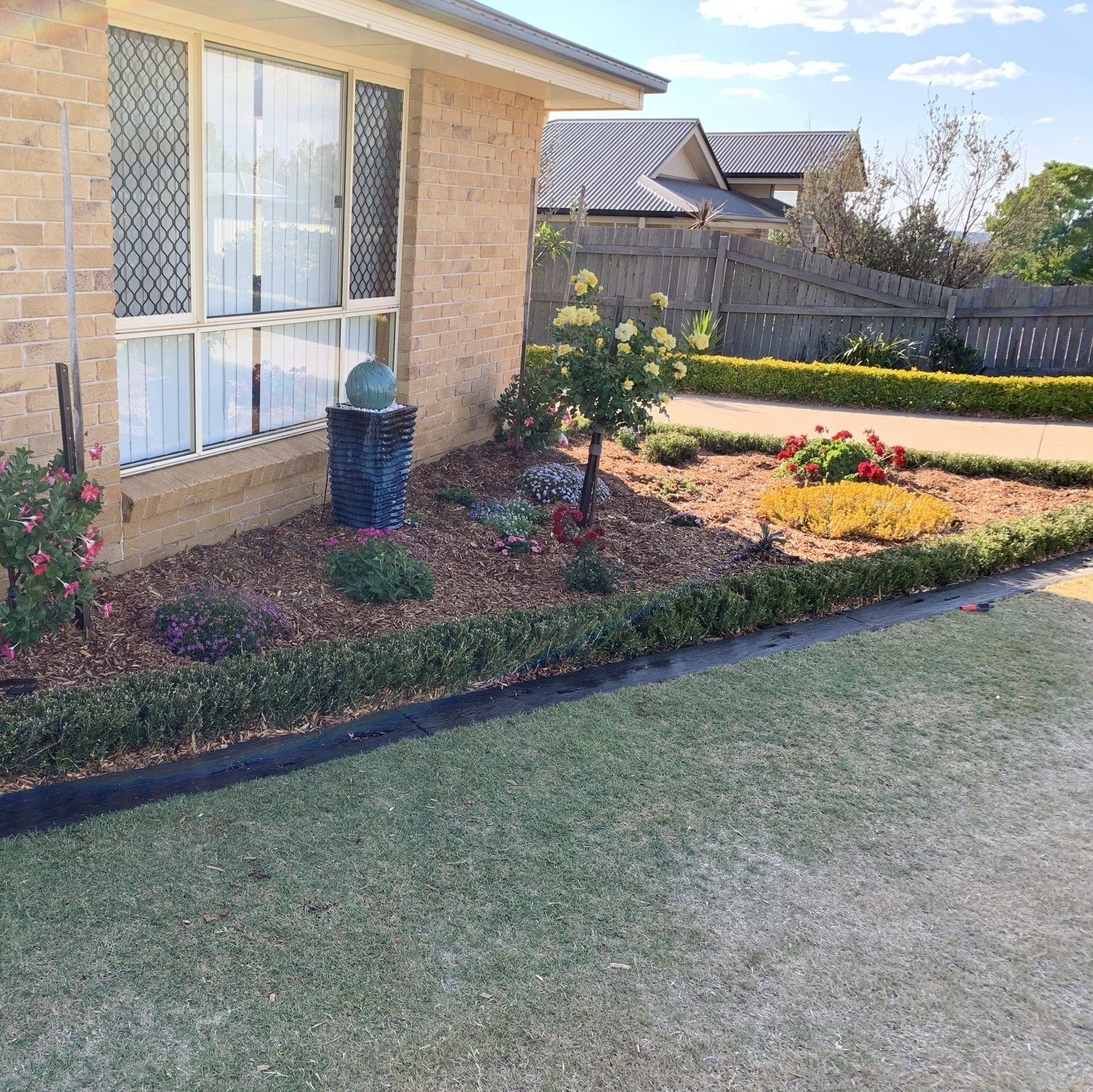 A brick house with a garden in front of it