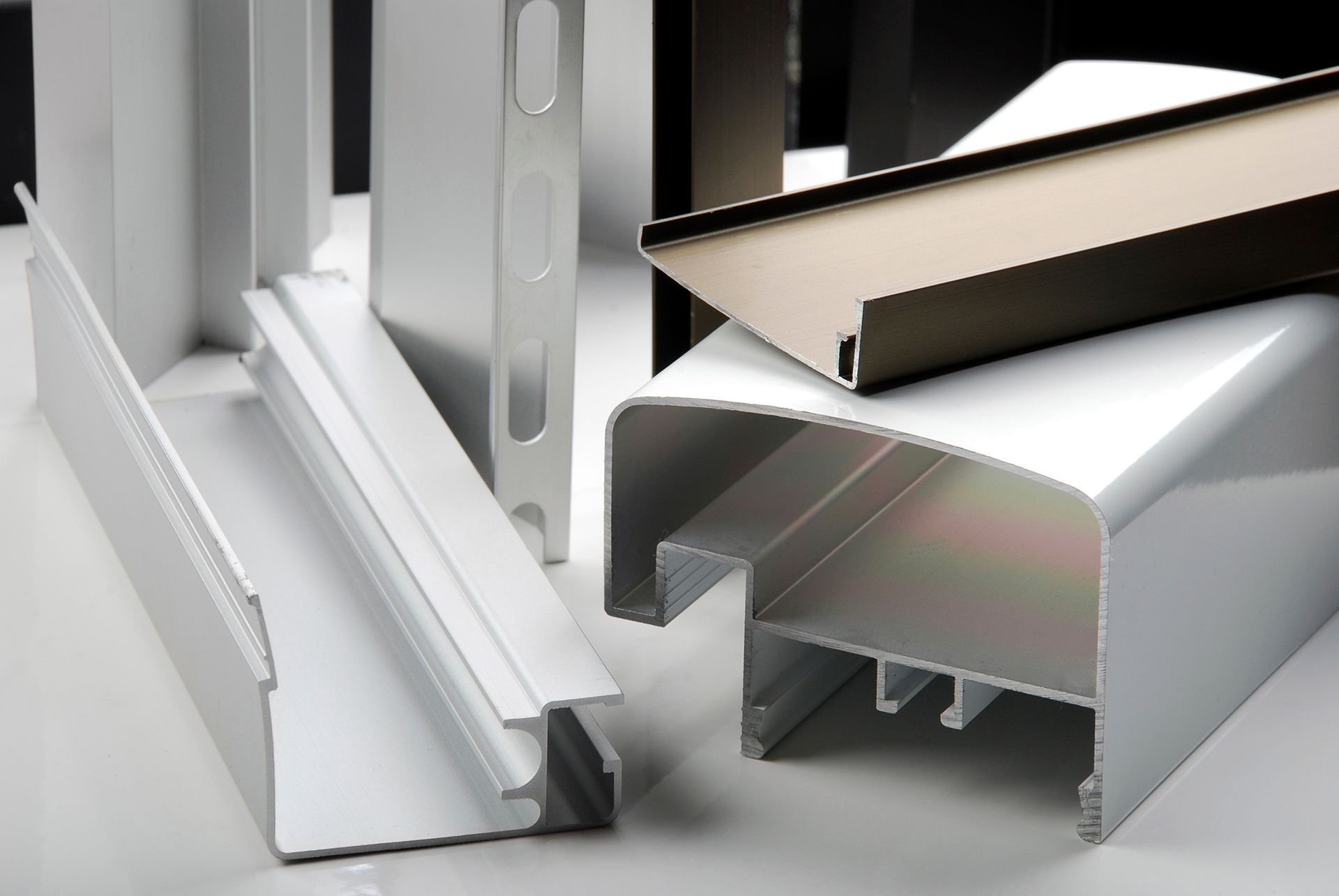 Se apilan varios tipos diferentes de perfiles de aluminio uno encima del otro.