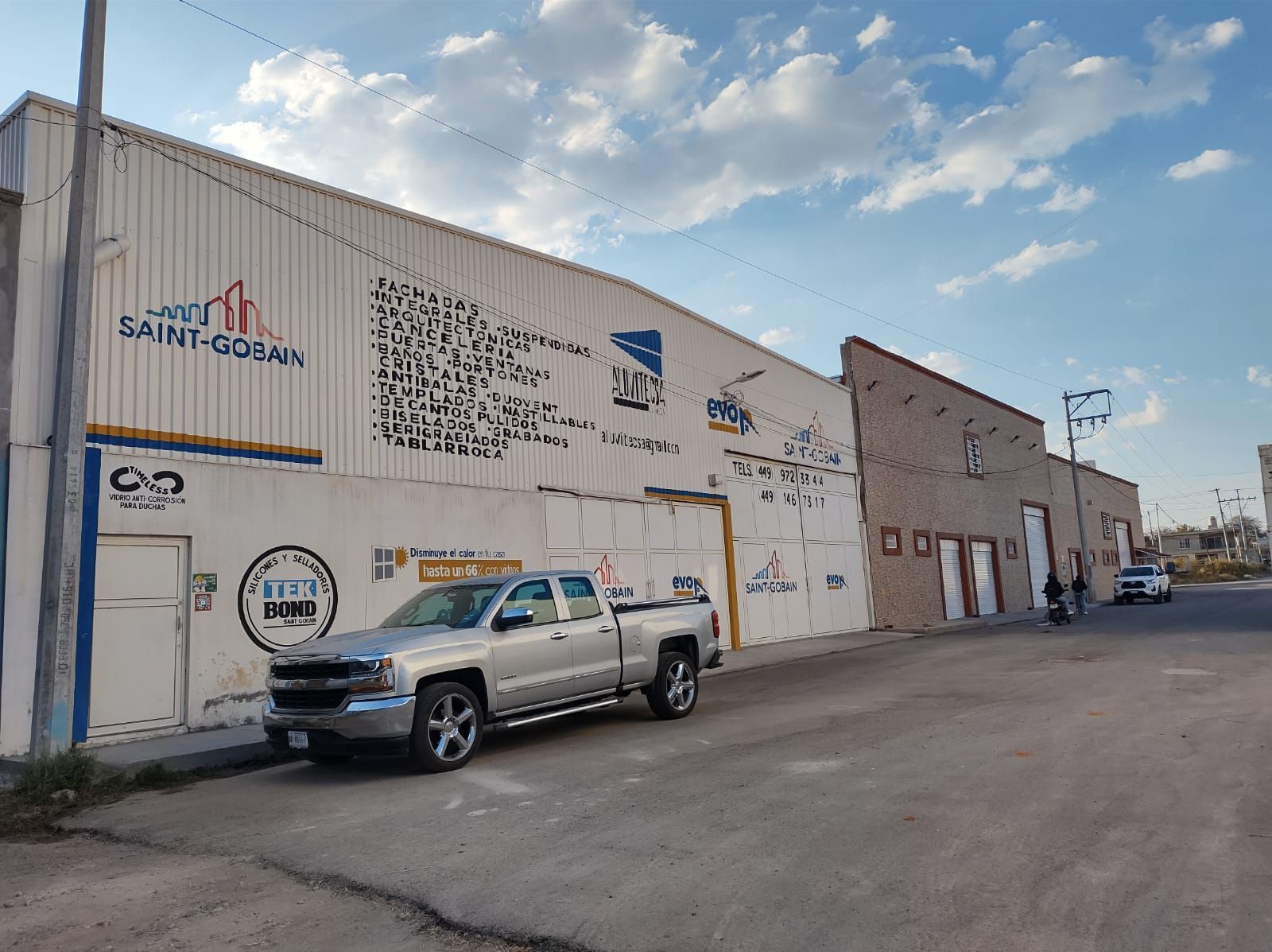 Un camión plateado está estacionado frente a un edificio que dice Santa Dora.