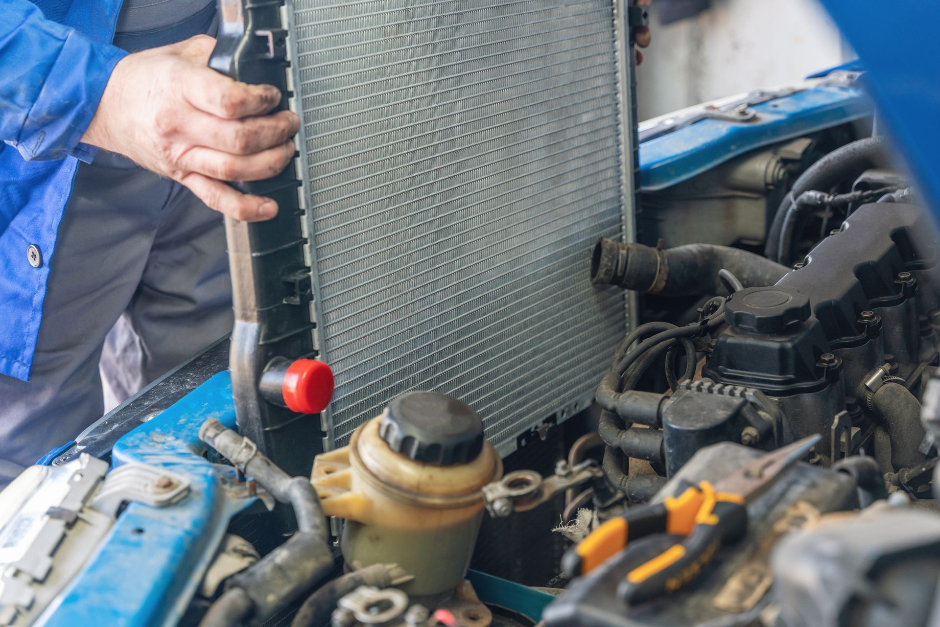 A man is installing a new radiator on a car.