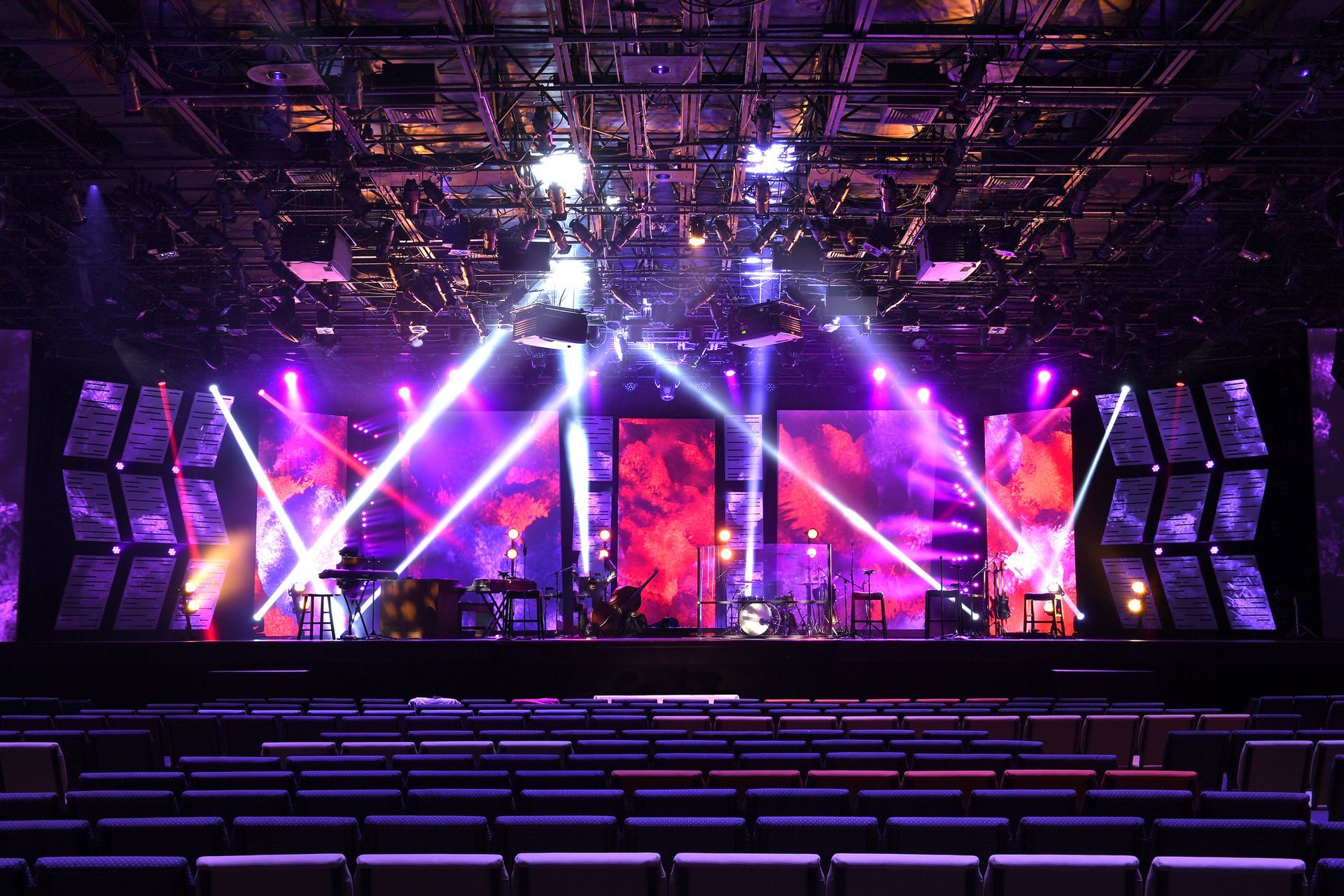Musical stage with instruments and purple and white lighting, showcasing event lighting.