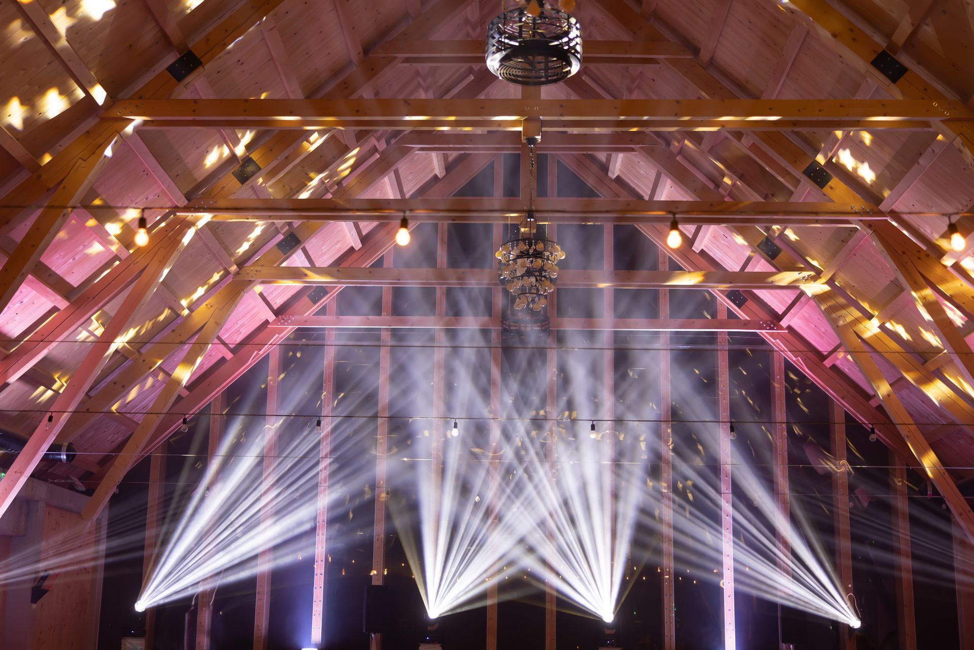 Powerful moving light beams on the ceiling structure in the interior of a corporate event.