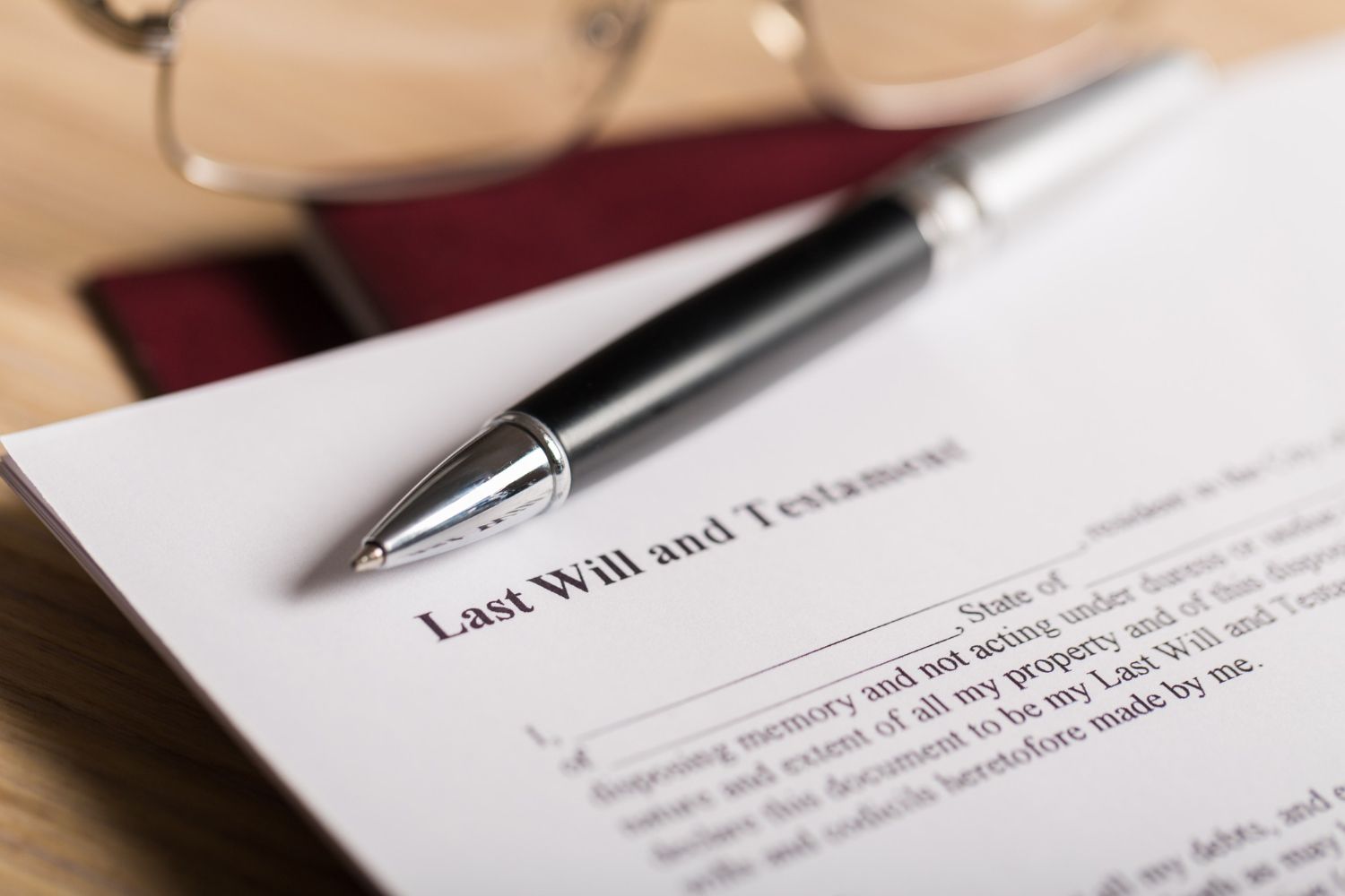 A pen is sitting on top of a last will and testament.