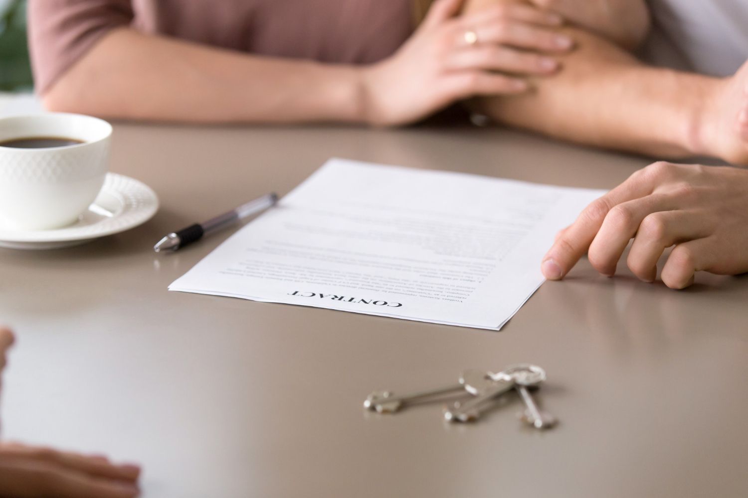 A couple is sitting at a table signing a contract.