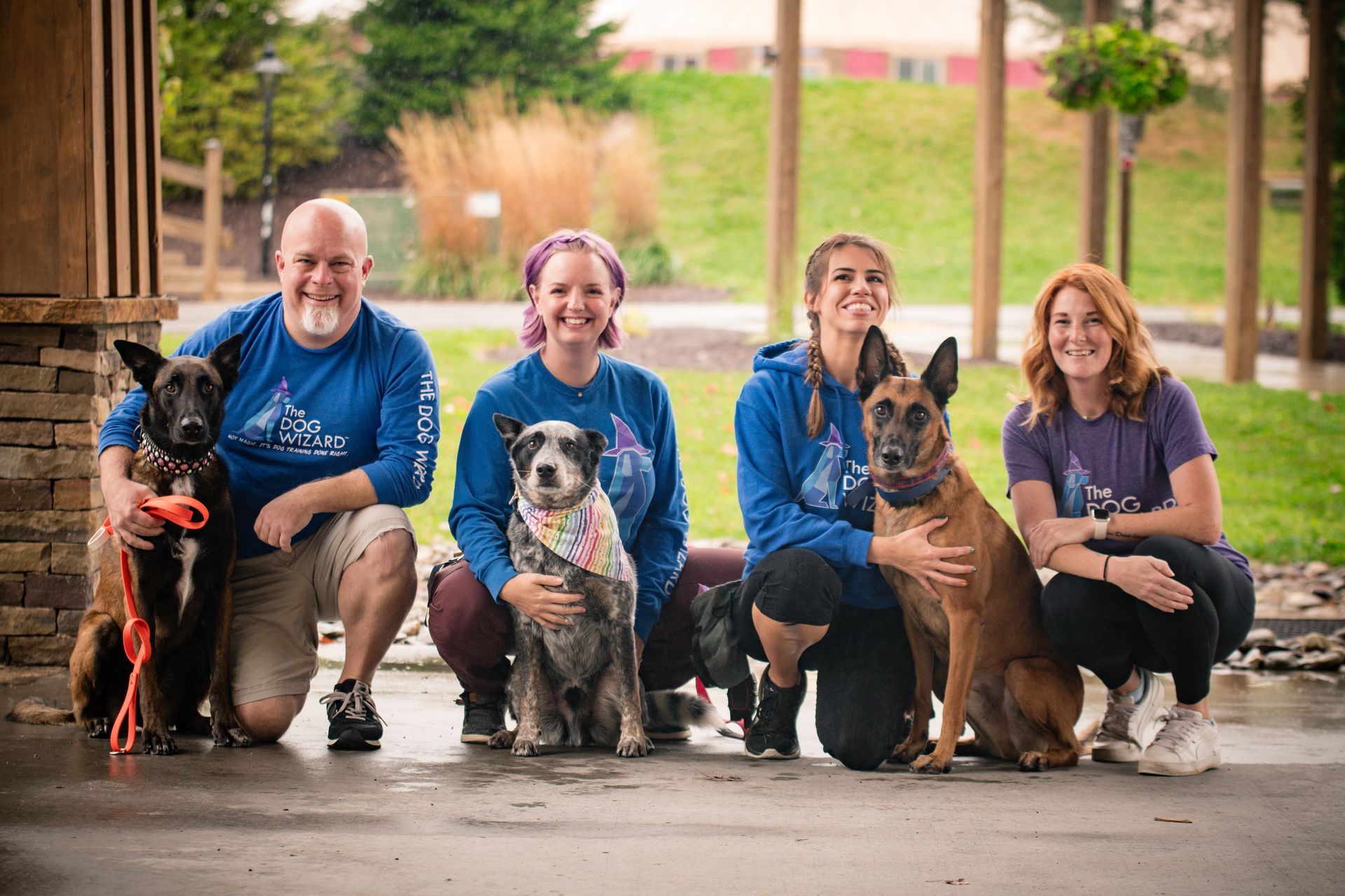 A group of people and their dogs are posing for a picture.