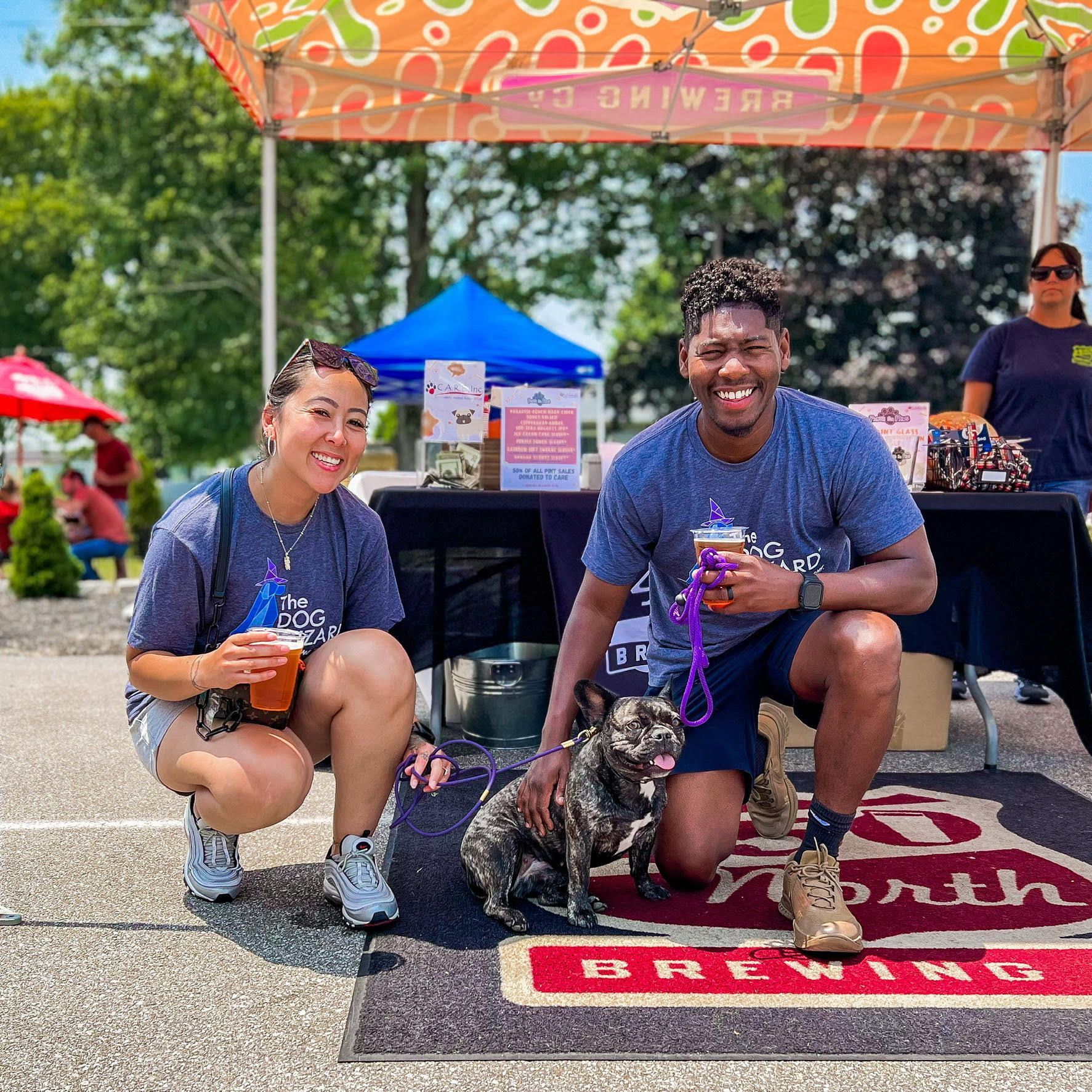A man and a woman are posing for a picture with their dog.