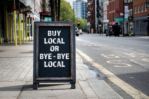 Black chalkboard sign on a sidewalk: 