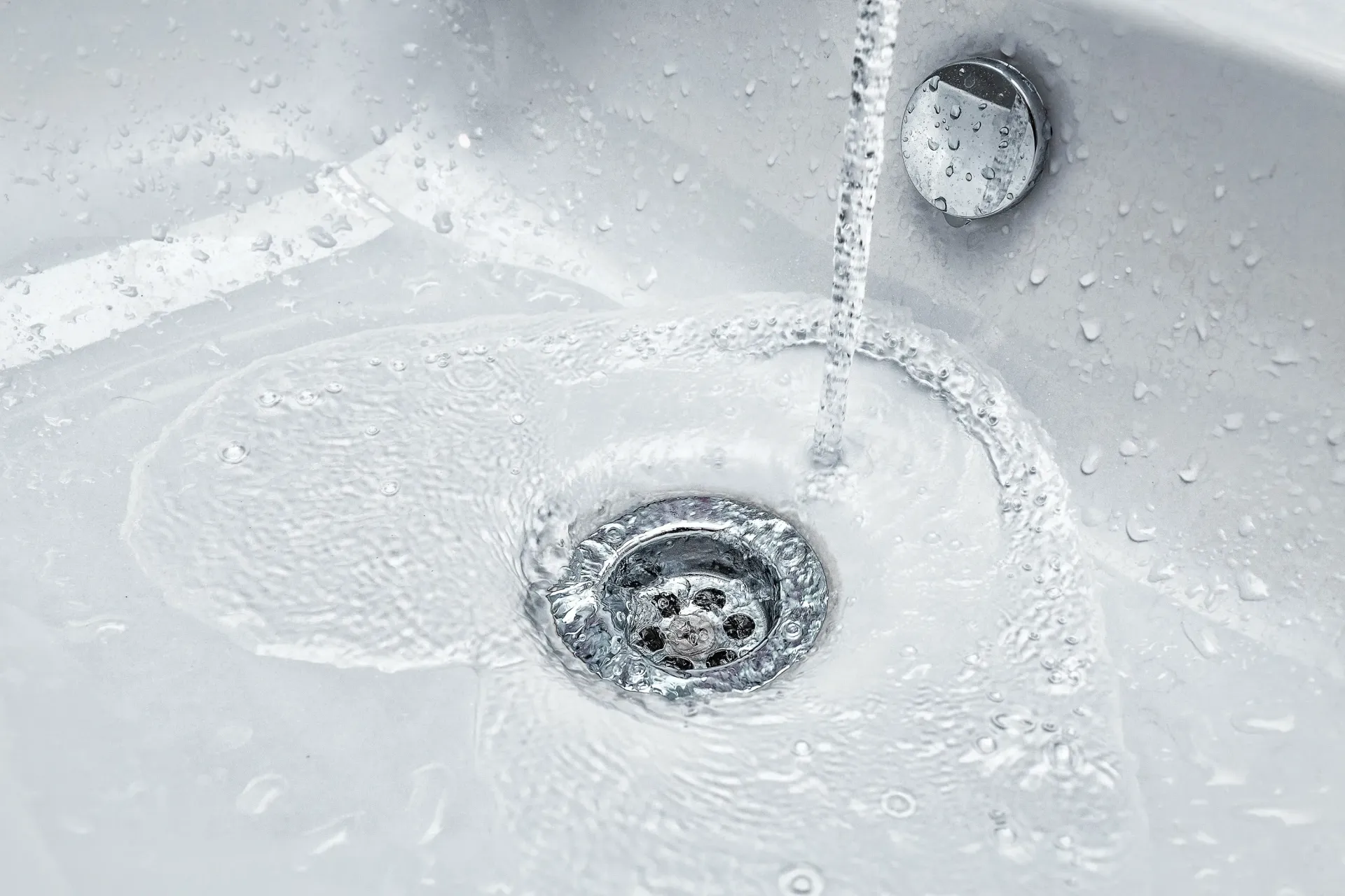 Water is running down the drain of a white sink in Southeast Portland