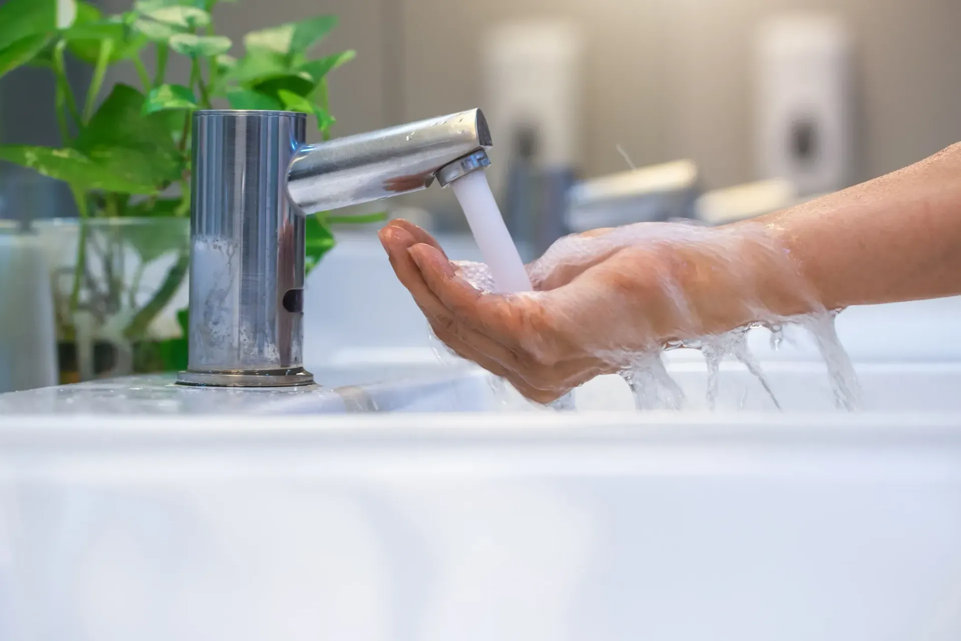 A person is washing their hands in a bathroom sink in Southeast Portland