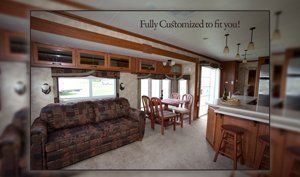 A living room with a couch , table and chairs in a mobile home.