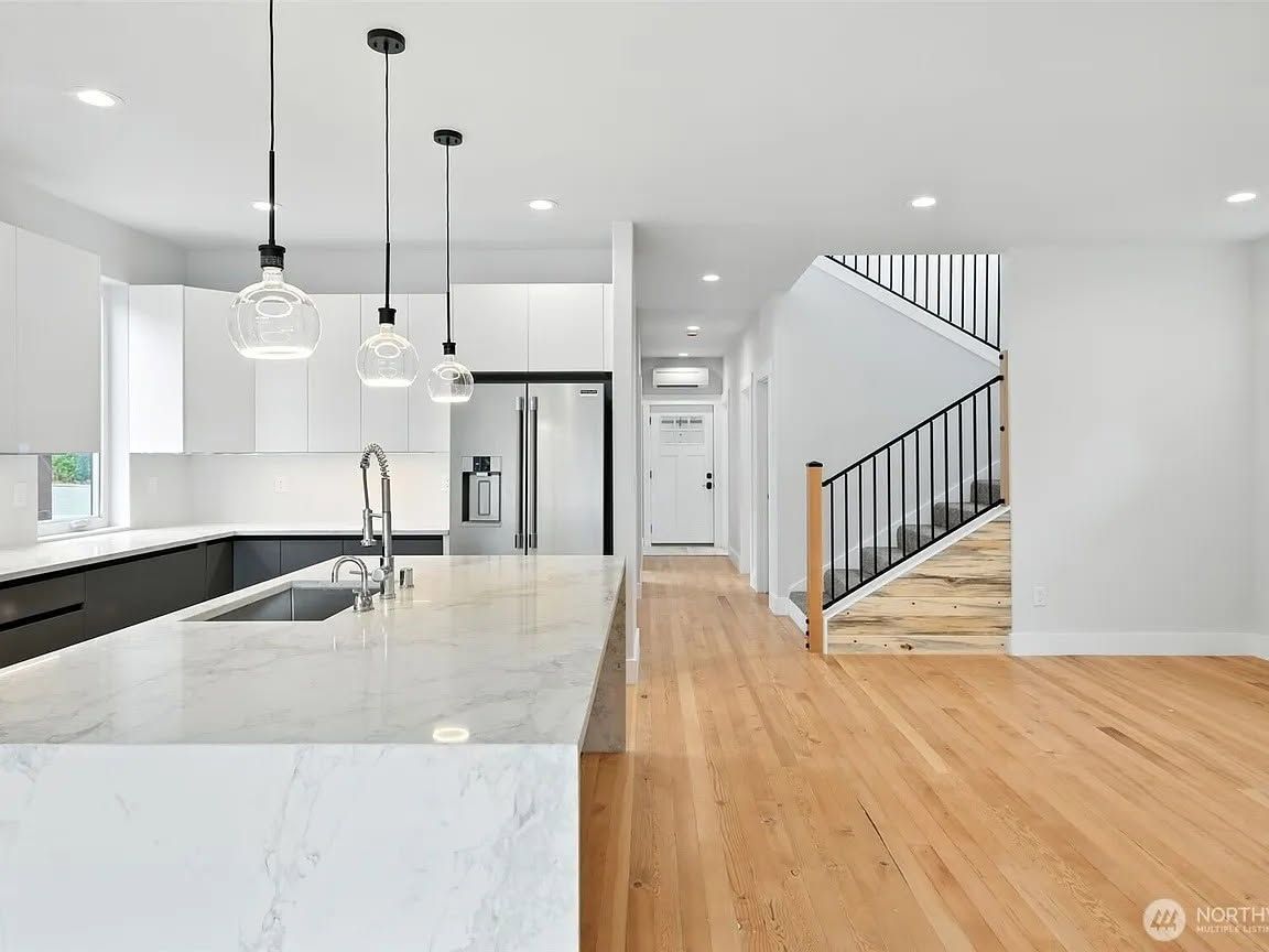 Person on a roof replacing metal panels. A ladder leans against the building. Overcast sky.