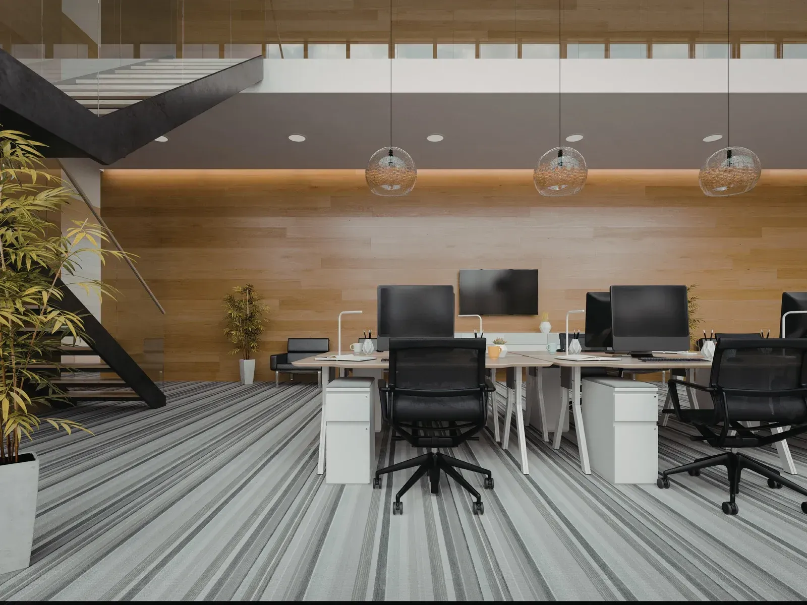 Modern office space with desks, chairs, computers, wood paneling, staircase, and decorative lighting.
